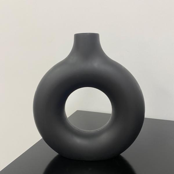 A round plastic vase is an artistic touch that suits your space. Add a touch of elegance and tranquility to your decor with this unique plastic vase.