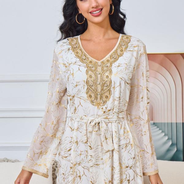 white dress embroidered with gold, a luxury that speaks of femininity