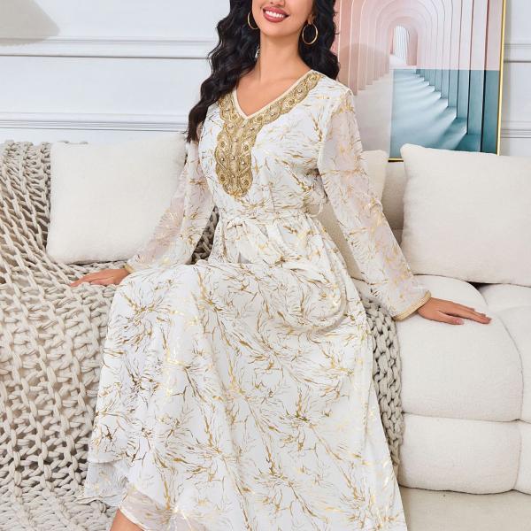 white dress embroidered with gold, a luxury that speaks of femininity