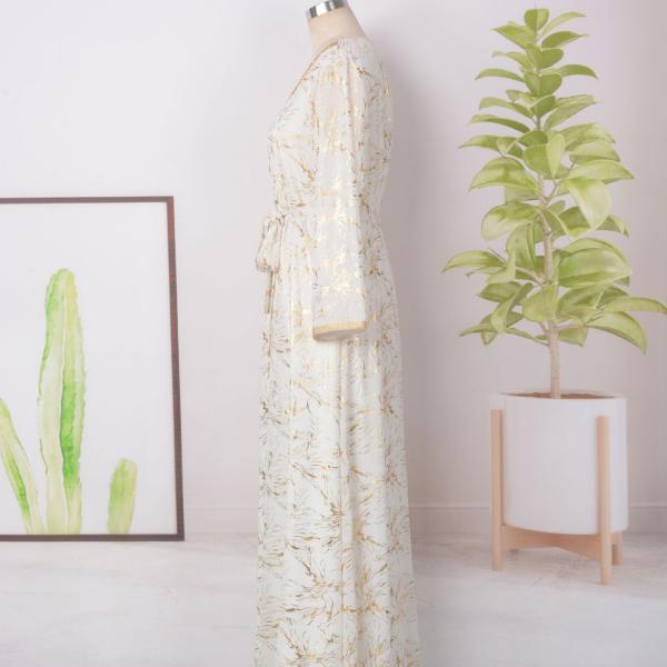 white dress embroidered with gold, a luxury that speaks of femininity