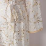 white dress embroidered with gold, a luxury that speaks of femininity