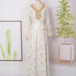 white dress embroidered with gold, a luxury that speaks of femininity