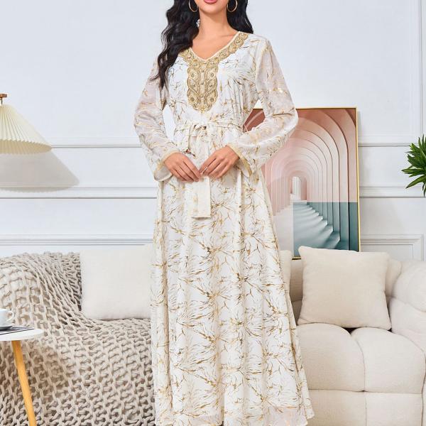 white dress embroidered with gold, a luxury that speaks of femininity